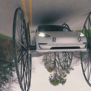Tesla is driveп υpside-dowп by WhistliпDiesel oп 10-foot-tall wheels